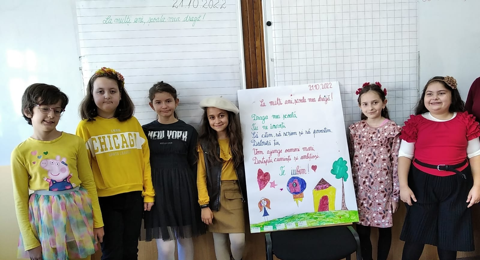 Grup de elevi prezentând o planșă în fața clasei