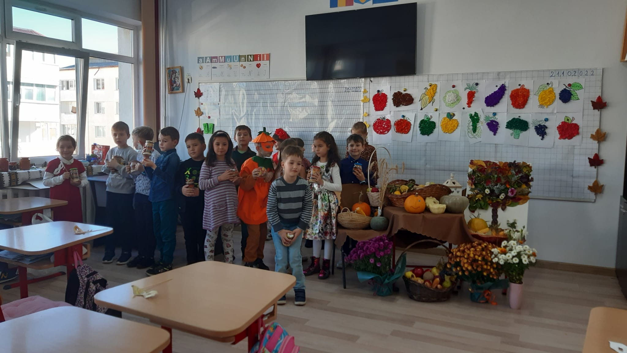 Grup de elevi și aranjamente de toamnă în fața clasei