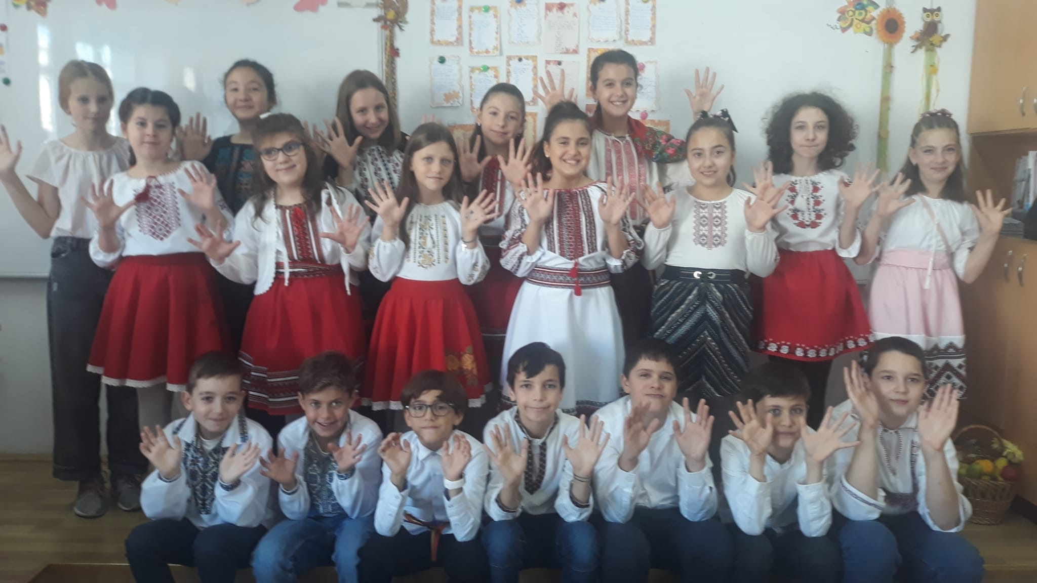 Grup de elevi în costume tradiționale în fața clasei