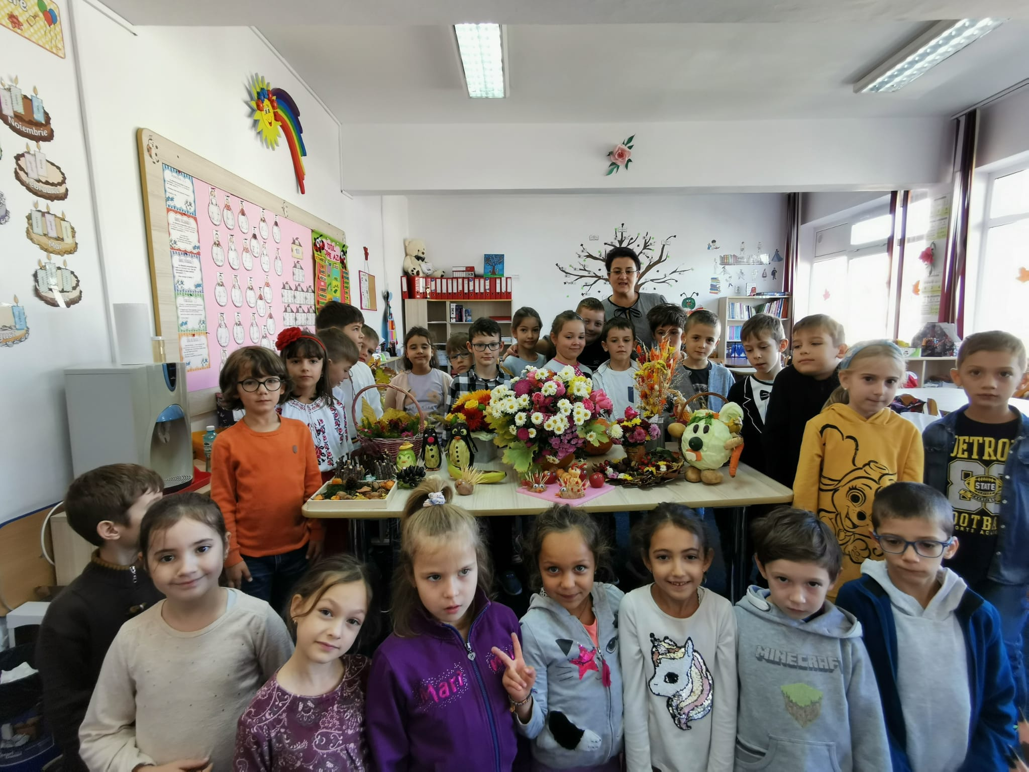 Grup de elevi și aranjamente de toamnă în sala de clasă