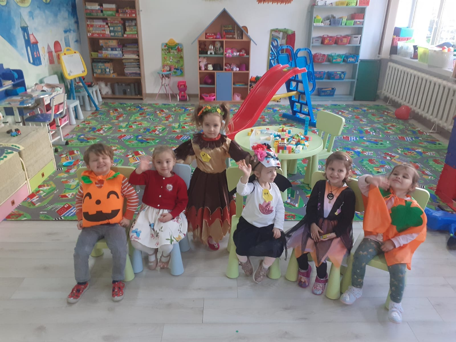 Grup de preșcolari în costume de Halloween în sala de grupă