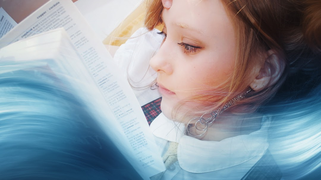 O elevă citește concentrată o carte, cu un efect de mișcare în jurul ei, care sugerează un flux rapid de informație și imaginație